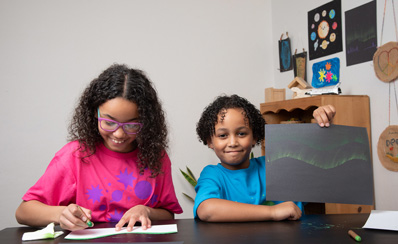Two children are coloring their own auroras