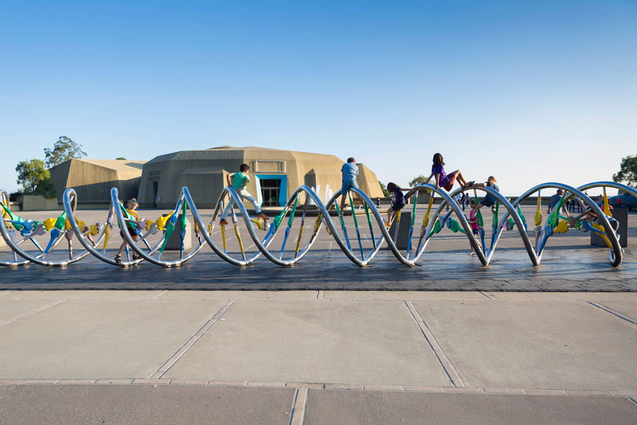 Children climbing on the DNA Sculpture on the plaza at The Lawrence