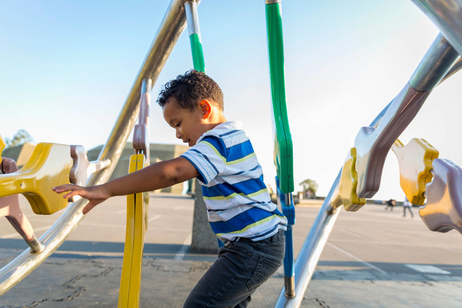 A child climbing on the DNA Sculpture on the plaza at The Lawrence