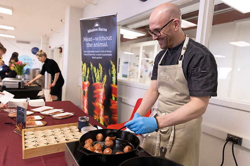 A person preparing Mission Barns lab-produced meatballs