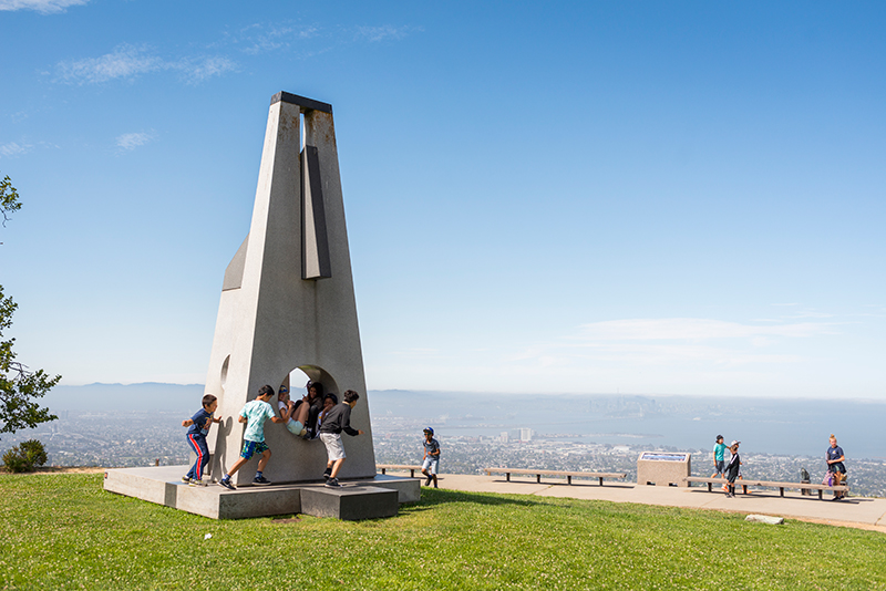 Visitors running and playing around the Sunstones sculpture at The Lawrence