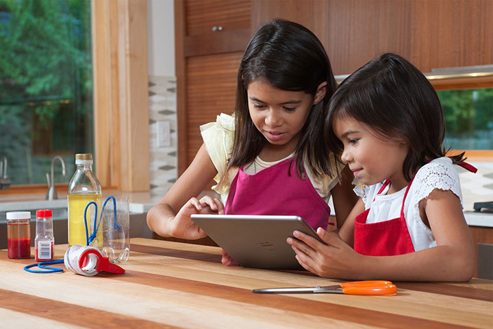 Two young people are using a science app on a tablet