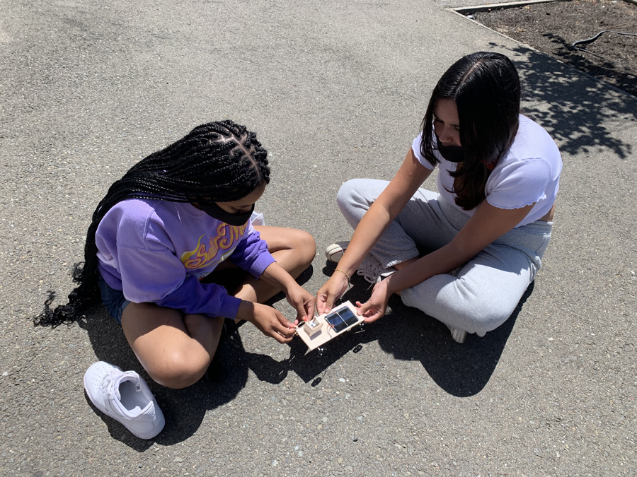 Two students are working on a solar project