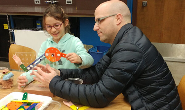 A child and an adult participating in the Ingenuity Challenges exhibit