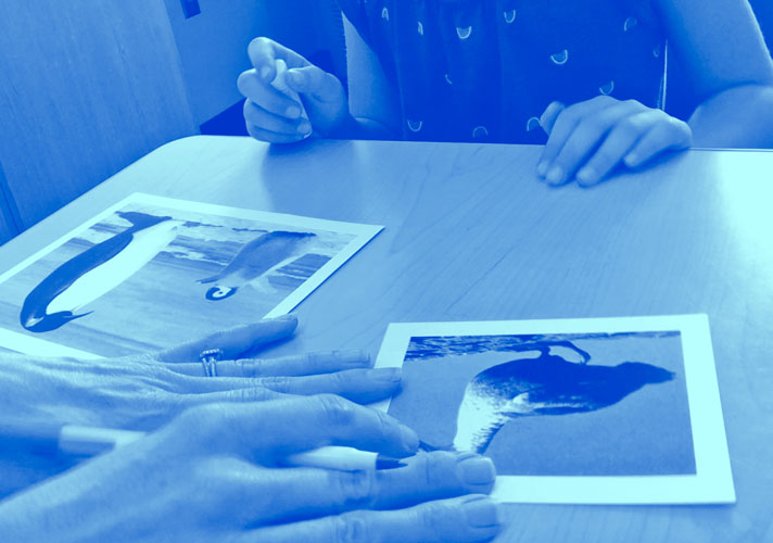 Two sets of hands as photos are examined.