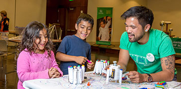 Two students and a teacher drawing during an activity