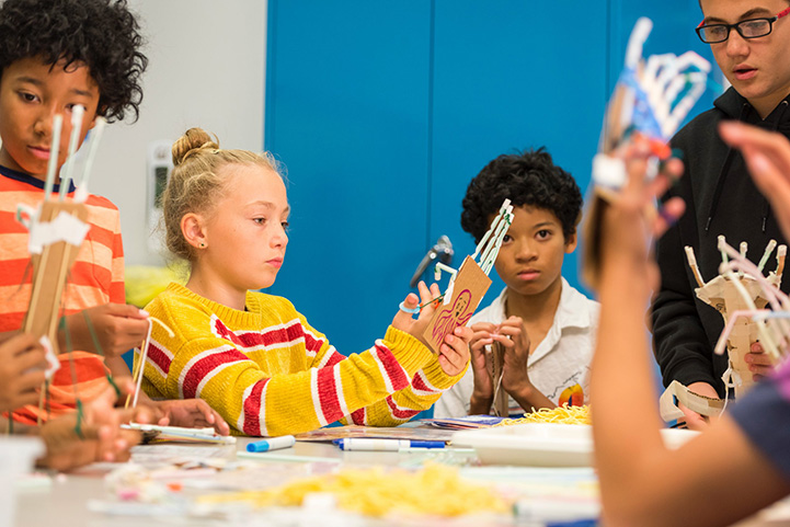 Four children and an adult constructing a science activity