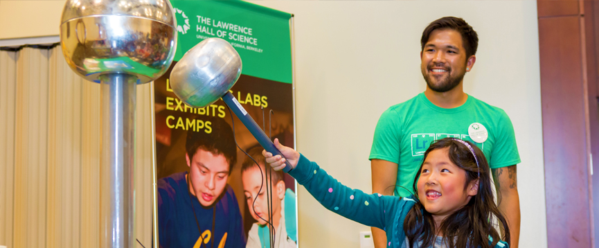 A young girl experiments with static electricity.