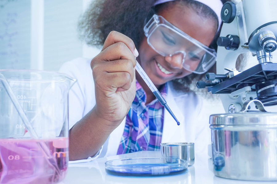 A student wearing safety glasses is testing a liquid in a laboratory