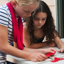Two young people using tape in their science experiment about weak and strong bones
