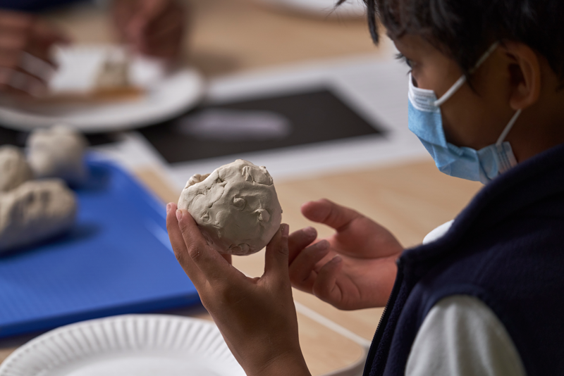 A camper is creating a model asteroid.
