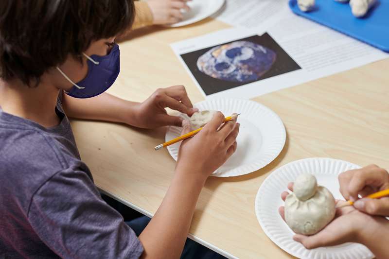 A camper is creating an asteroid during the Asteroid Adventure Summer Camp.