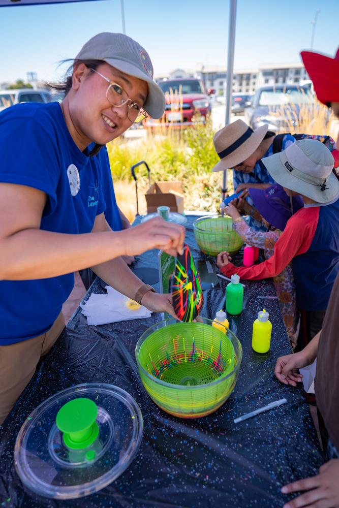 A staff member is demonstrating an activity at a Lawrence On-The-Go event
