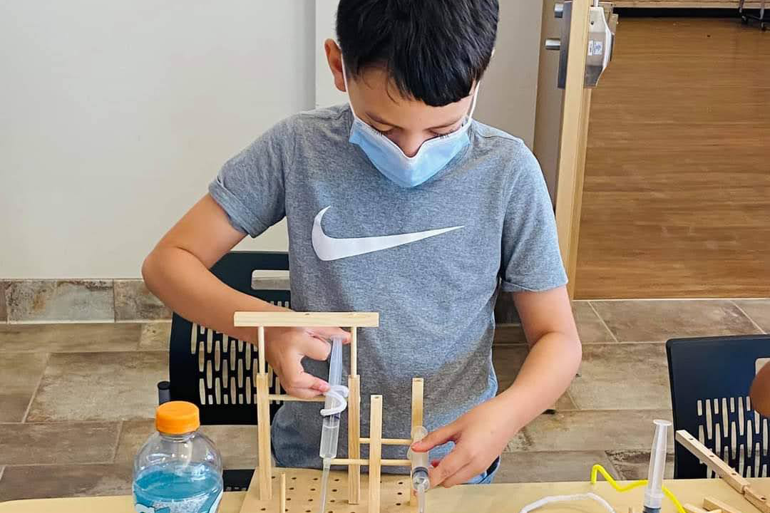 A student constructs an invention during the Make It Move workshop