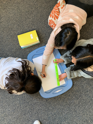 Three students participate in a Make Math REAL activity.