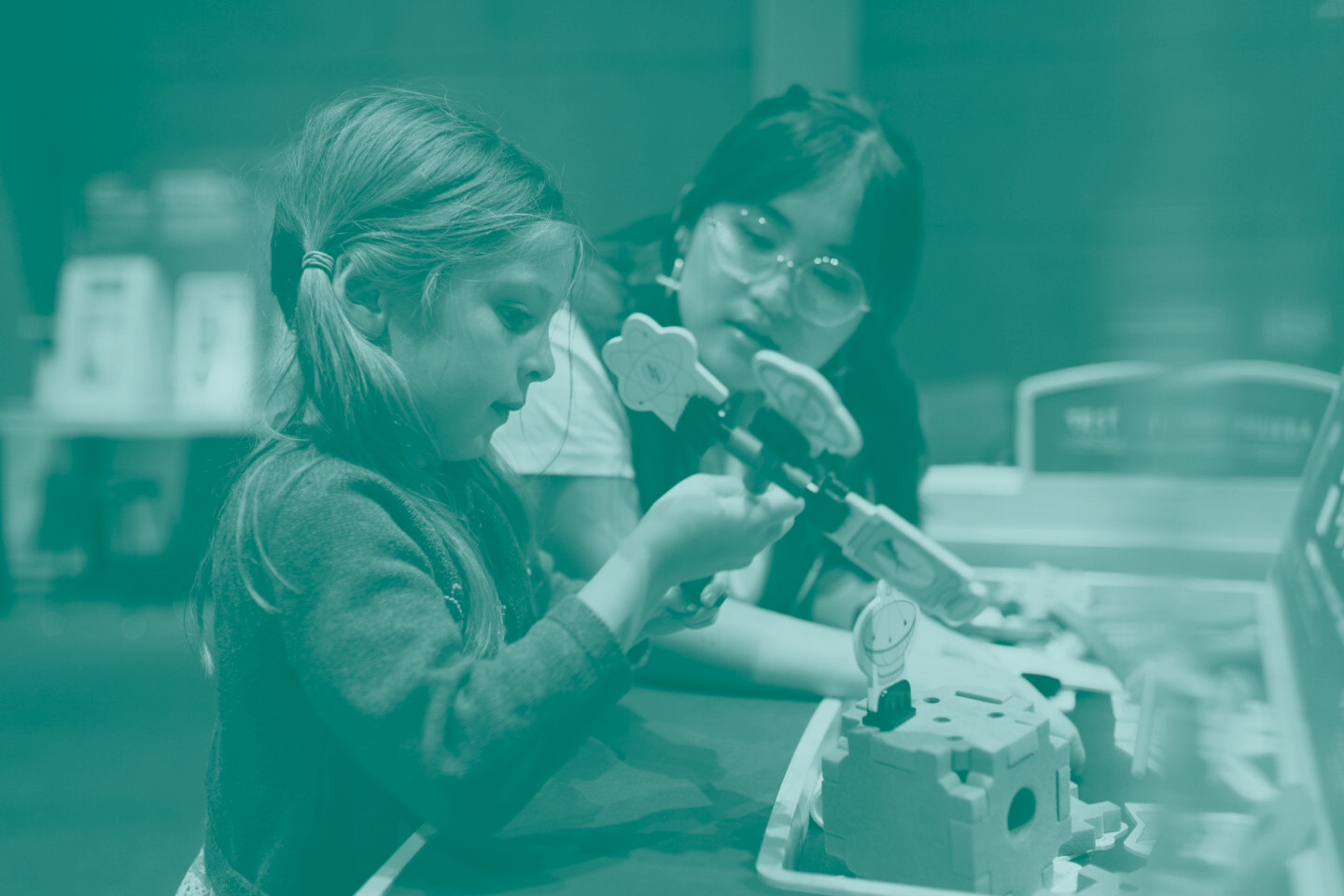 A child and an adult work together on a science project at an exhibit at The Lawrence.