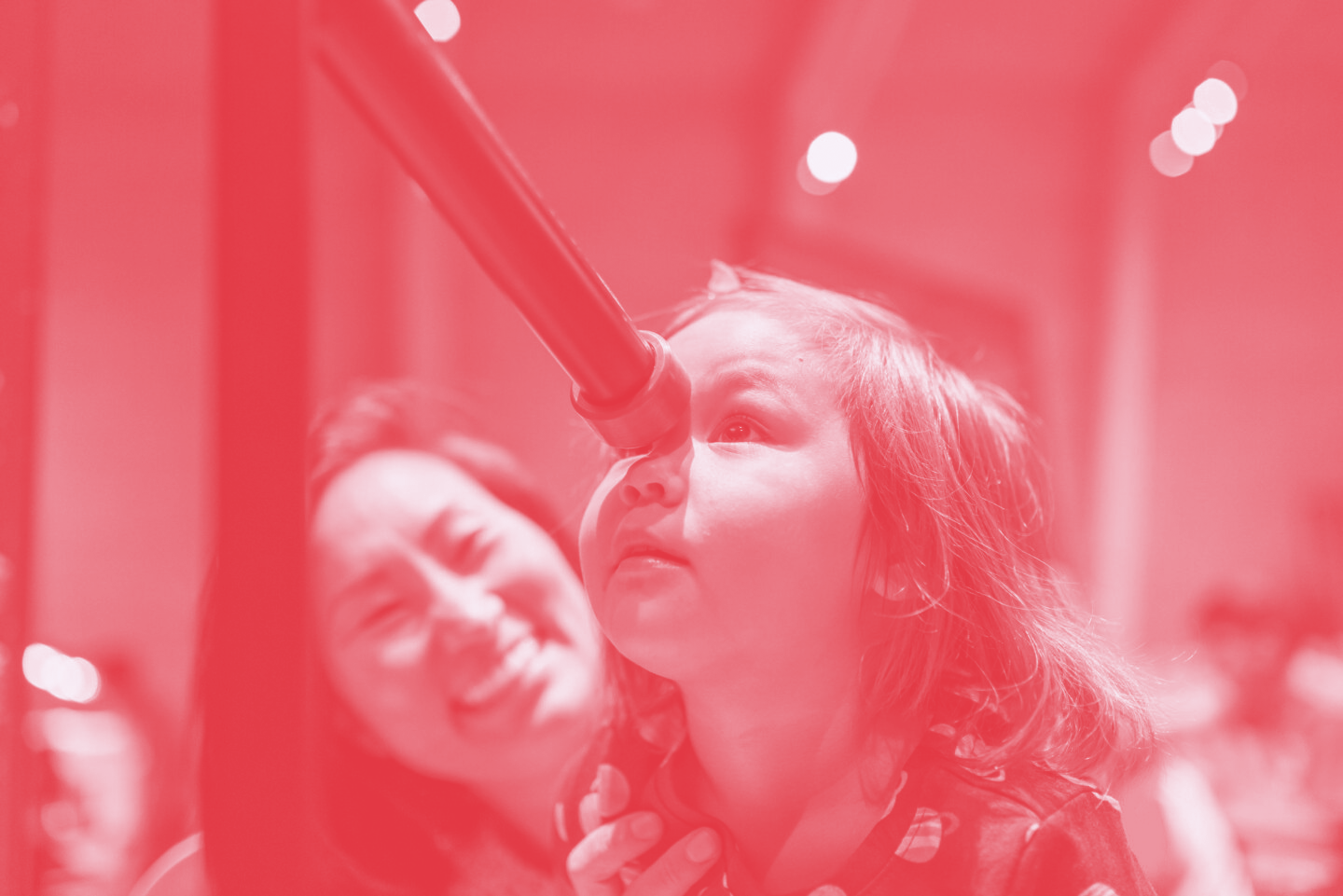 A child looks through a telescope.