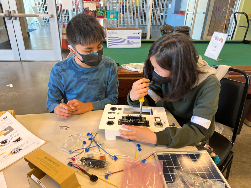 Students from the YESS program are building solar suitcases.