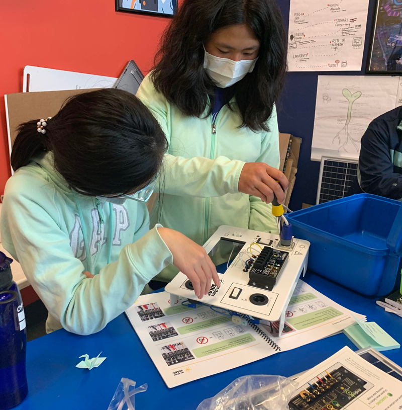 Students from the YESS program are building solar suitcases.